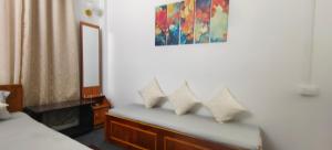 a bedroom with a bench with four pillows on it at Mirik Homestay in Mirik