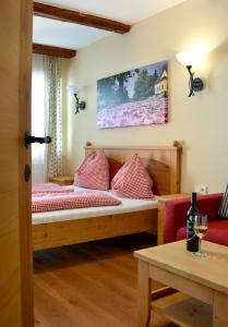 a bedroom with a wooden bed with red pillows at Weingut Buschenschank Schneiderannerl in Gleinstätten