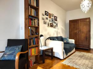 a living room with a couch and a book shelf with books at Apartament Skorpion Centrum in Sanok