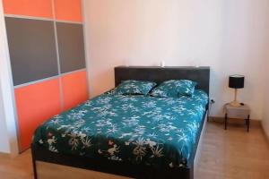 1 dormitorio con 1 cama con edredón verde en Le cocon rochois en Roches-sur-Marne