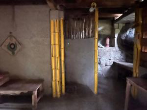 ein Zimmer mit gelben Stangen in der Ecke eines Zimmers in der Unterkunft Arana Rathnaella Eco Lodge in Hassalaka