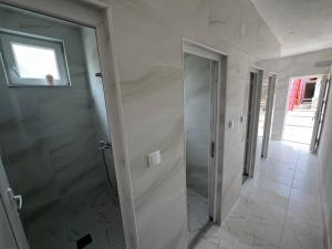 baño con ducha a ras de suelo y puerta de cristal en Rural Tourism/Ruralni Turizam Kisin, en Trebinje
