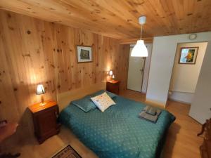 a bedroom with a bed in a room with wooden walls at La Ressource in Villars-Colmars