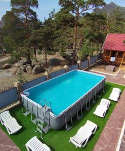 a swimming pool with lounge chairs and a swimming poolvisorvisor at Goluboy Zaliv in Borovoye