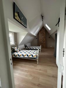 a bedroom with two beds in a attic at Le cottage des quatre vents in Gouchaupré
