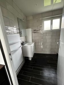 a small white bathroom with a sink and a window at Le cottage des quatre vents in Gouchaupré +33 photos