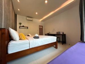 a bedroom with a large bed with yellow pillows at Phangan Hometown Resort - Adults Only in Ban Tai