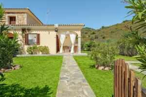 a house with a green yard with a fence at New Villa Carmen in San Teodoro