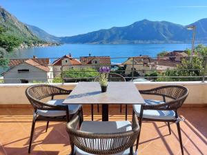 a table and chairs on a balcony with a view at Secret Mirage Apartment in Kotor
