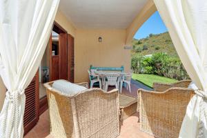a patio with wicker chairs and a table on a porch at New Villa Carmen in San Teodoro