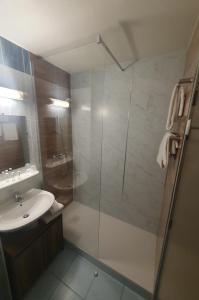 ein Bad mit einer Dusche, einem Waschbecken und einem WC in der Unterkunft Hotel Salea in Pornic