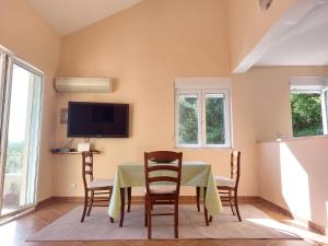 a dining room with a table and chairs and a tv at Secret Mirage Apartment in Kotor