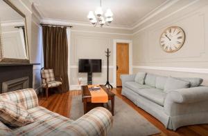 uma sala de estar com um sofá e um relógio na parede em Amazing 3 BR Apartment in Prime Location em Nova York