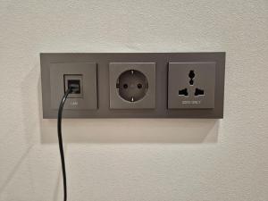 a lightswitch on a wall with a cord plugged into it at Gwang Jang Hotel in Busan