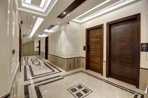 a hallway with wooden doors and a tile floor at The Vanson Pride, Delhi Central Stay in New Delhi