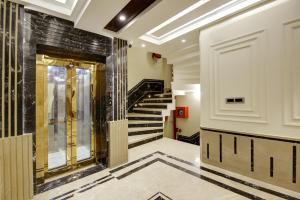 a hallway with a staircase with black and gold tiles at The Vanson Pride in New Delhi