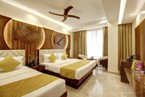 Cette chambre comprend deux lits et un ventilateur de plafond. dans l'établissement The Vanson Pride Delhi, à New Delhi