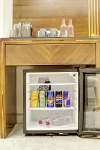 a small refrigerator with its door open in a kitchen at The Vanson Pride Delhi in New Delhi