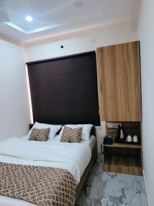 a bedroom with a large bed with a large black headboard at NANDI RETREAT HomeStay in Varanasi