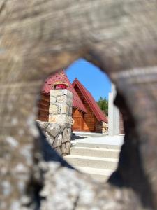 a view of a building through a hole in a rock at Rural Tourism/Ruralni Turizam Kisin in Trebinje