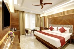 a hotel room with a bed and a television at The Vanson Pride, Delhi Central Stay in New Delhi