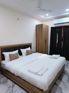 a bedroom with a large bed with white sheets at NANDI RETREAT HomeStay in Varanasi