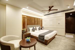 a bedroom with a bed and a chair and a table at The Vanson Pride in New Delhi +47 photos