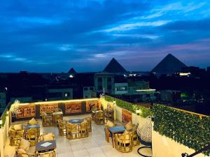 a rooftop patio with tables and chairs at night at king of pharaohs pyramids view in Cairo