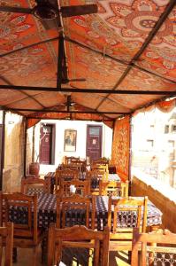 una sala da pranzo con tavoli, sedie e soffitto a motivi geometrici di Killa Bhawan Lodge a Jaisalmer