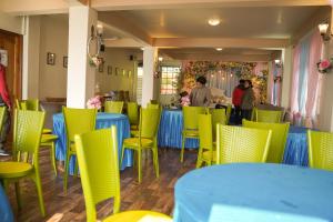 a dining room with blue tables and yellow chairs at MISSION VALLEY Kalimpong in Kalimpong