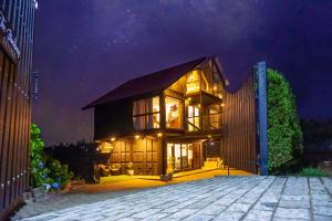 a large house with glass doors at night at The Blackberry Cottage in Nuwara Eliya
