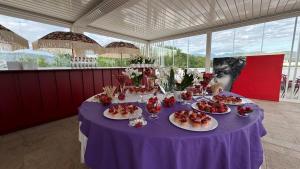purpurowy stół z talerzami żywności w obiekcie NOLA BOUTIQUE HOTEL - self check- w mieście Nola