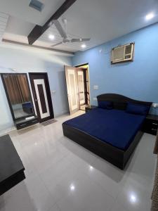 a bedroom with a large bed in a blue wall at Kusum Villa in Varanasi