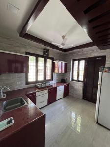 a large kitchen with a sink and a refrigerator at Kusum Villa in Varanasi