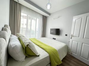 Çiftlikköyにあるmerkezde 2 odalı minimalist evのベッドルーム1室(黄色い毛布付きのベッド1台付)