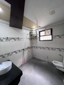 a bathroom with two toilets and a window and a sink at Kusum Villa in Varanasi