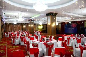 un salón de banquetes con mesas y sillas rojas y blancas en UB City Hotel, en Ulán Bator