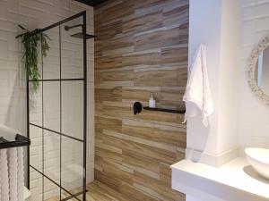 a bathroom with a shower with wooden tiles at Buckingham Studio in Pinetown