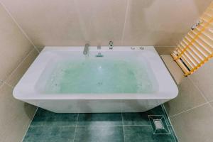 a white bath tub sitting in a bathroom at Pacific Apartment & Hotel Phu Quoc in Phu Quoc
