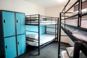 a room with three bunk beds in a dorm room at Nomads St Kilda in Melbourne +37 photos