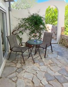 a patio with two chairs and a table on a stone patio at Marilen in Livadia