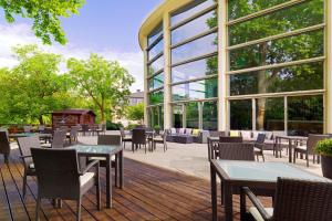 a patio with tables and chairs and a building with windows at Sheraton Offenbach Hotel in Offenbach