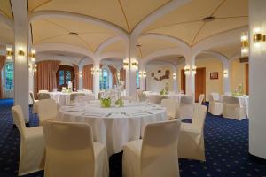 una sala de banquetes con mesas blancas y sillas blancas en Sheraton Offenbach Hotel, en Offenbach