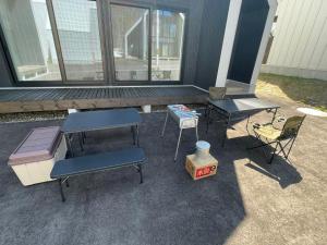 a patio with two tables and a grill and chairs at 【ペット可】Niseko STREAM Villas in Rankoshi