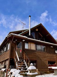 uma casa de madeira com neve nas escadas e uma boca de incêndio em beau lac biwako - Vacation STAY 25030v em Takashima