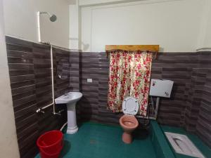 uma casa de banho com um WC cor-de-rosa e um lavatório. em Niangti Guest House em Dawki