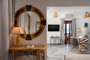 a living room with a table and a mirror at Skinopi Fisherman's house in Péran Triovasálos +10 photos