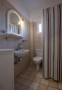 a bathroom with a sink and a toilet and a mirror at Azure Nikiti in Nikiti