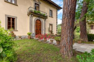 una casa con un patio con macetas y un árbol en Luxury apartment vicino Firenze, en Londa
