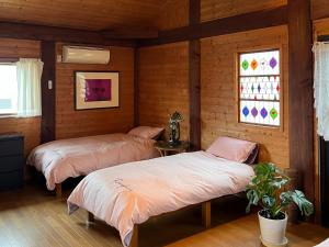 Duas camas num quarto com paredes e janelas de madeira em beau lac biwako - Vacation STAY 25030v em Takashima